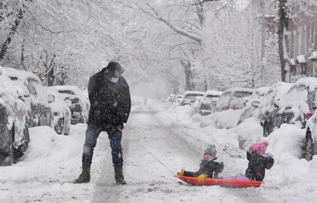 A person pulling children on a sled in the Windsor Terrace neighborhood of Brooklyn, New York City as a snow storm hits the area on Super Bowl Sunday.